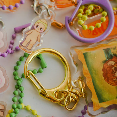 Collection of colorful keychains with various designs on a white background