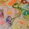 Collection of colorful keychains and charms on a white background
